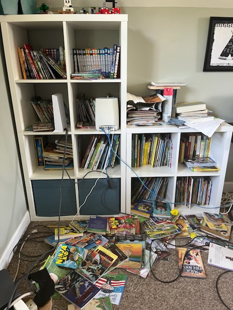 messy book shelf area before maid service