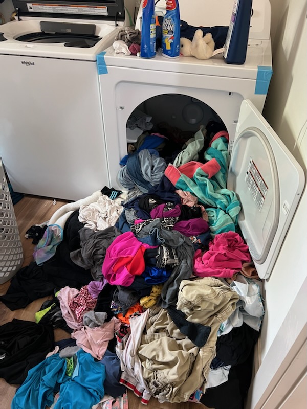 laundry spilling out of dryer